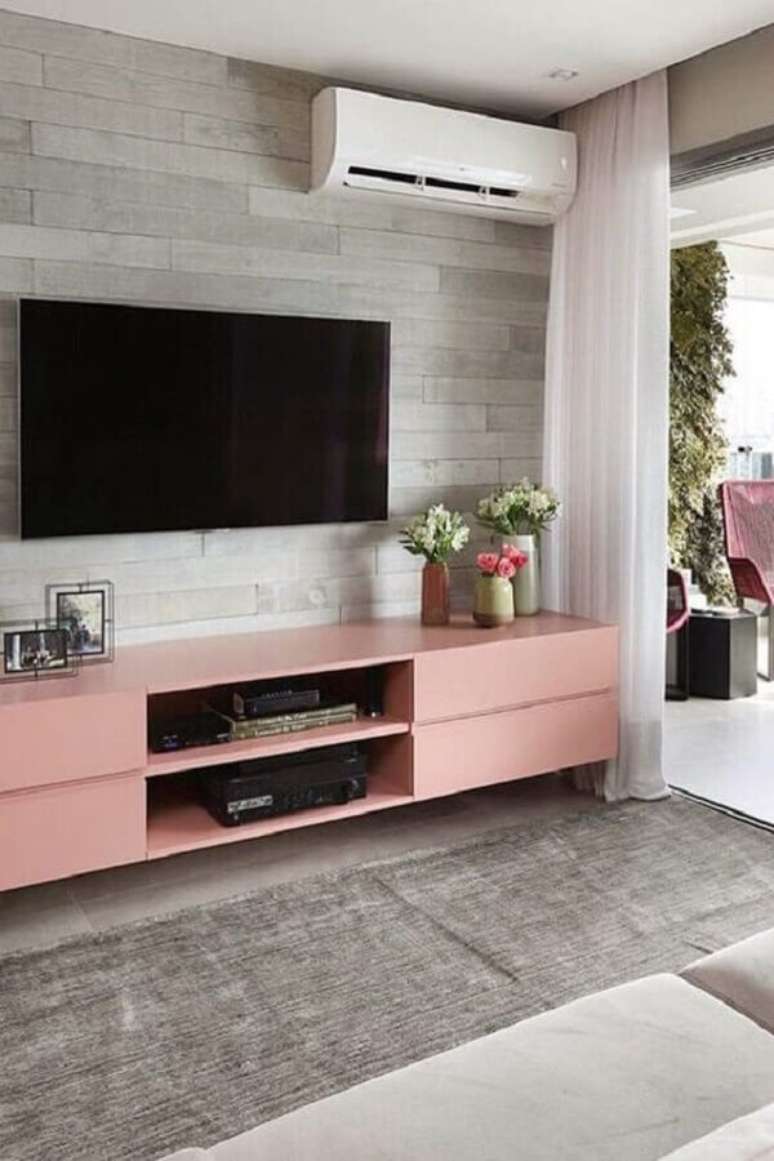 25. Decoração de sala com rack cor de rosa e TV direto na parede – Foto: Eu Capricho