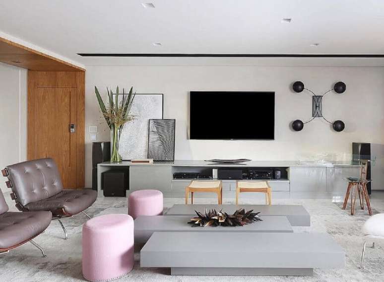 7. Decoração de sala ampla moderna com tv na parede e puffs cor de rosa – Foto: Futurist Architecture