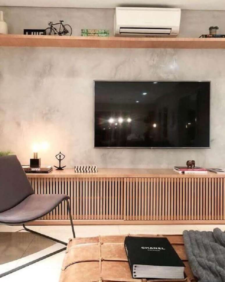 33. TV direto na parede de cimento queimado de sala moderna com rack de madeira – Foto: Archilovers