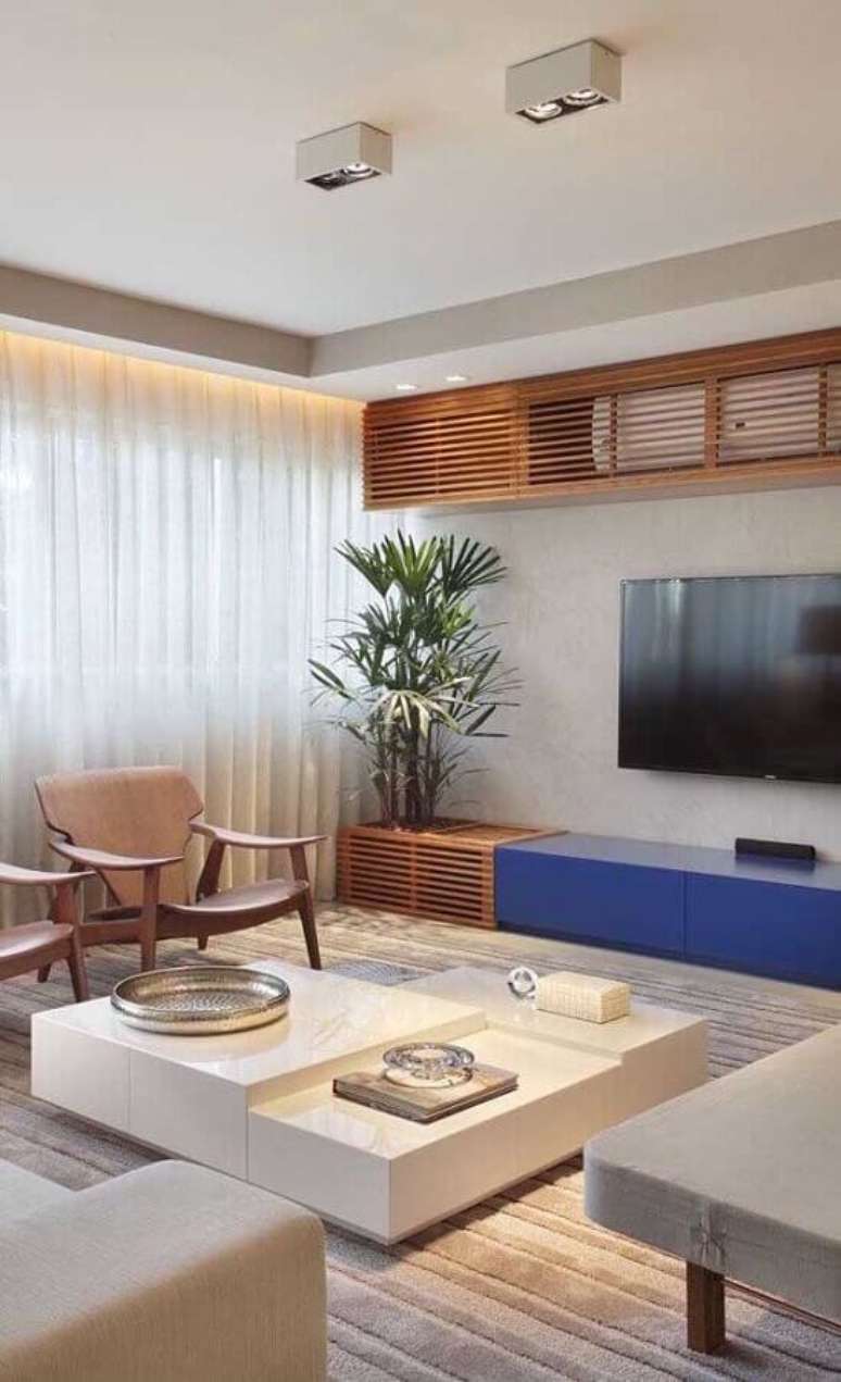 34. Decoração moderna para sala com TV na parede e rack planeada azul – Foto: Apartment Therapy