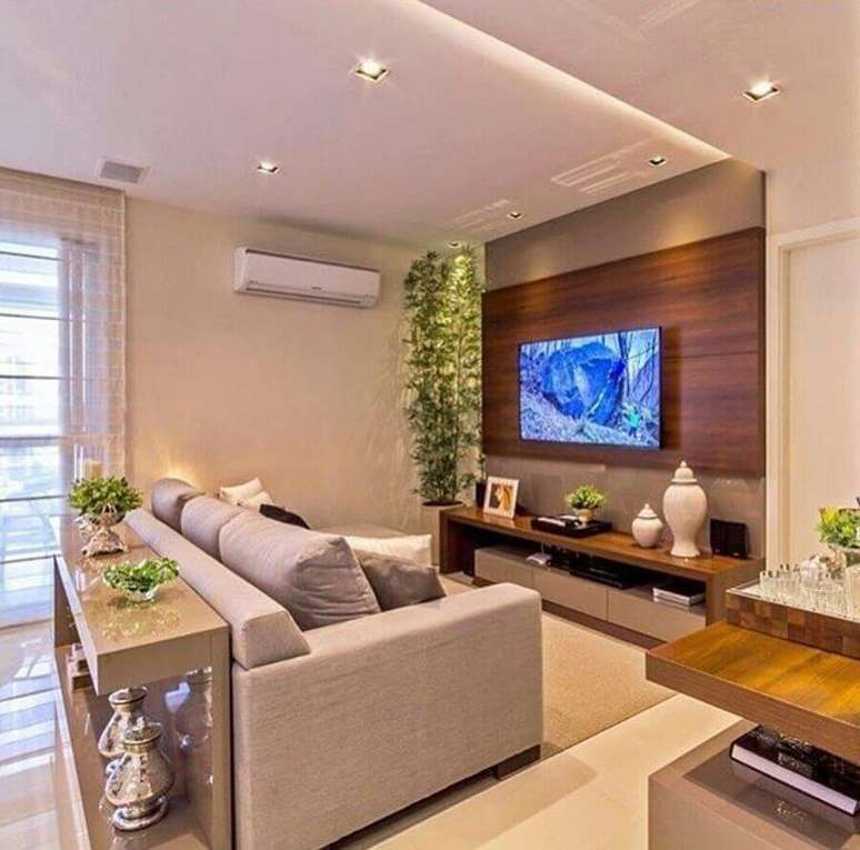 45. Sala de estar decorada com sofá cinza e suporte para TV na parede – Foto: Pinterest