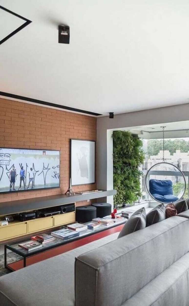 56. TV direto na parede de tijolo à vista de sala planejada moderna – Foto: Futurist Architecture