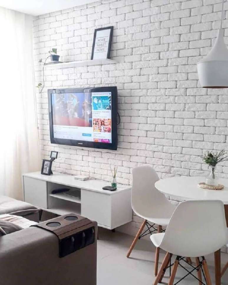 57. Decoração de sala branca pequena e simples com TV na parede sem painel – Foto: We Heart It