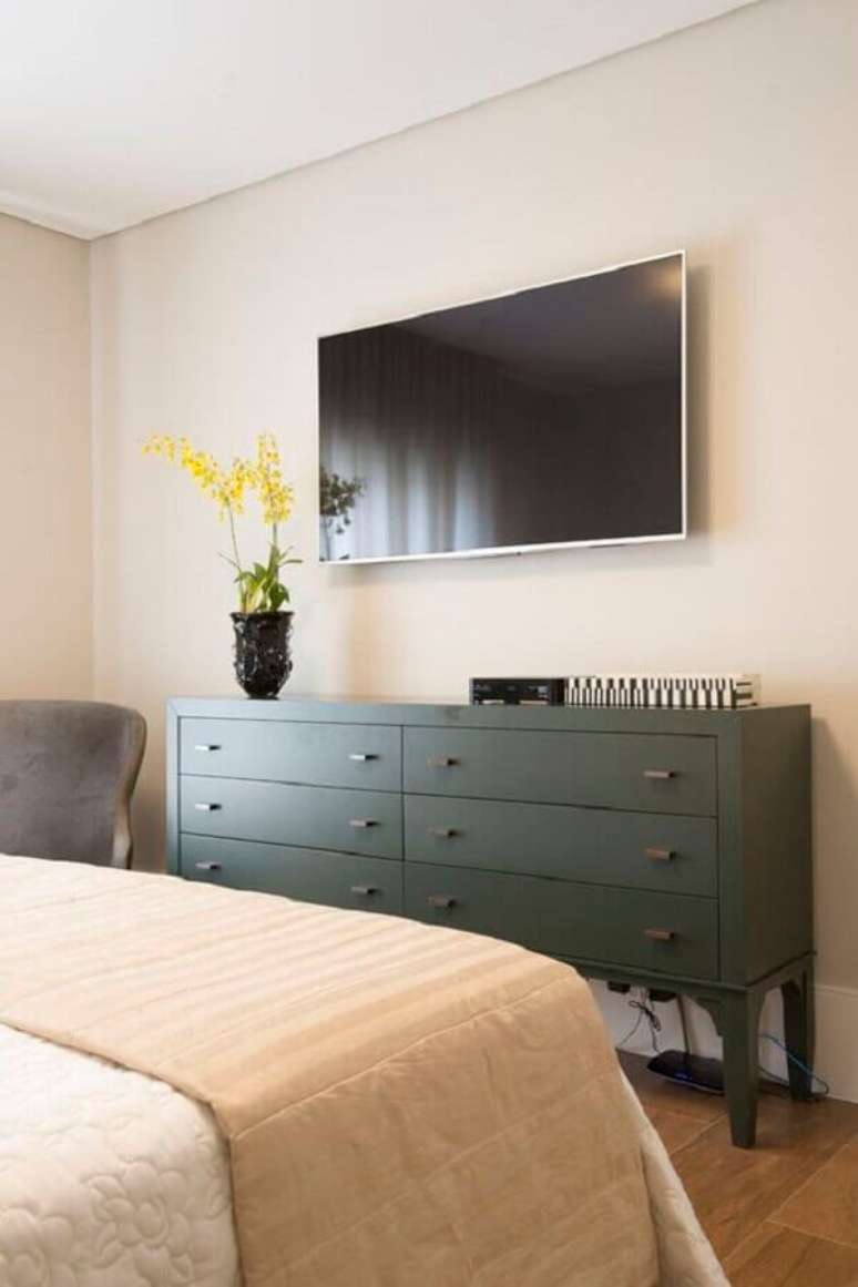 58. TV na parede do quarto decorado com cômoda verde escuro – Foto: Pinterest