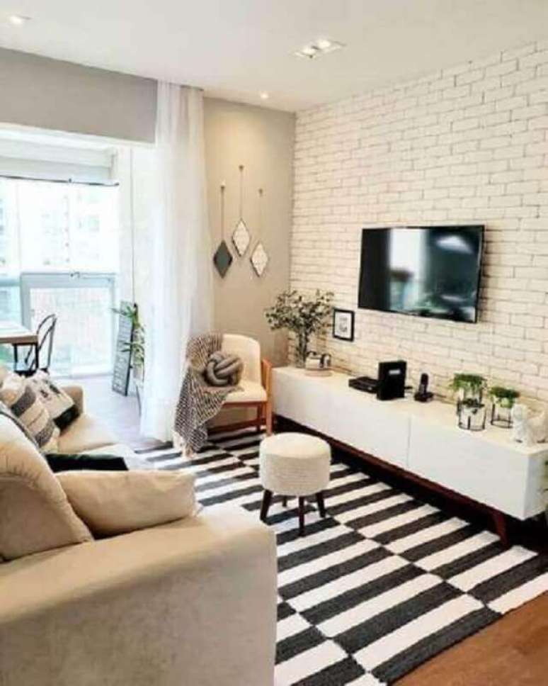 63. Sala branca decorada com tapete listrado preto e branco e TV na parede sem painel – Foto: Pinterest