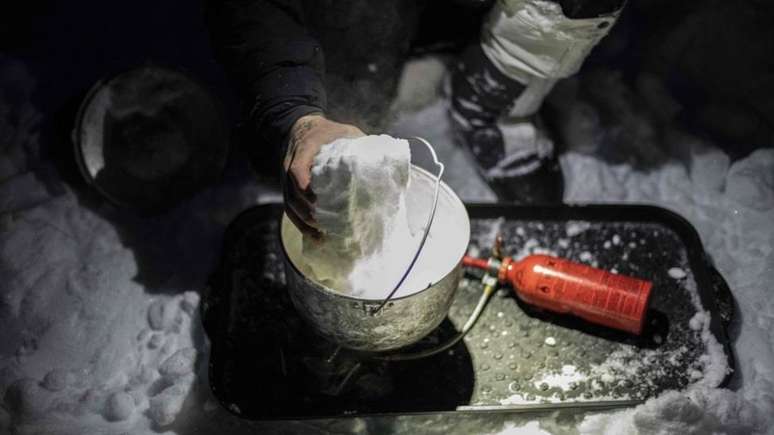 Um soldado francês derrete a neve como parte de um exercício de treinamento