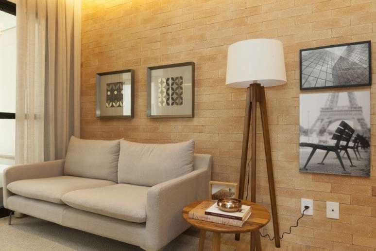 15. A parede de tijolinho aparente foi decorada com diversos quadros para sala de TV. Fonte: Très Arquitetura