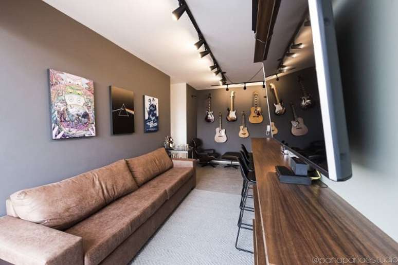 49. Quadros decorativos e sof&aacute; com tecido marrom complementam a decora&ccedil;&atilde;o. Fonte: Panapan&aacute; Est&uacute;dio de Projetos