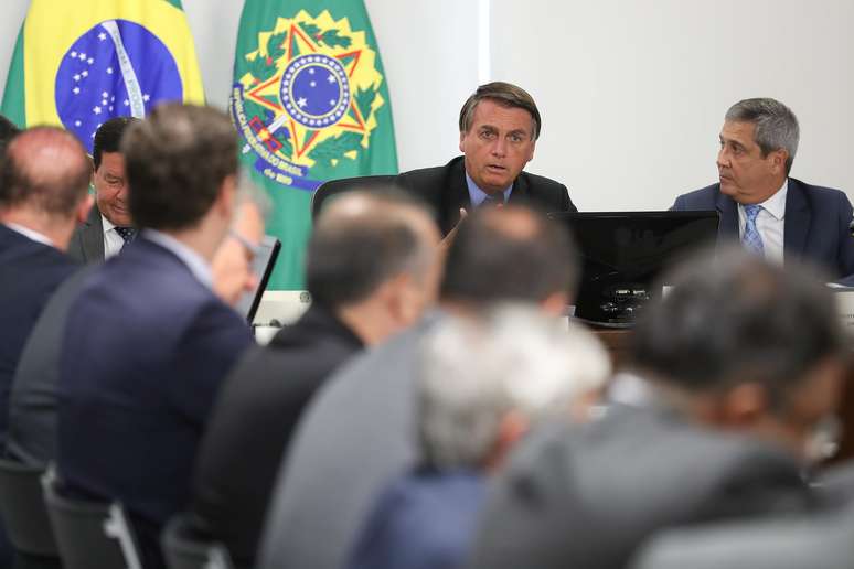 Jair Bolsonaro conversa com os ministro durante reunião do governo