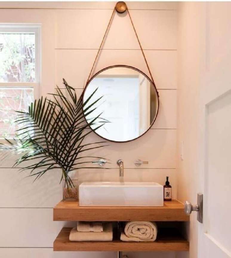 18. Modelo de espelho redondo para banheiro com alça de couro – Foto: Fratelli House