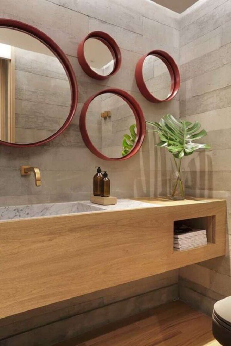 27. Decoração de banheiro moderno com gabinete planejado e vários espelhos para banheiro redondo com moldura vermelha – Foto: Casa de Valentina