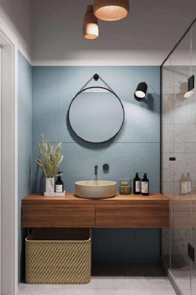 38. Banheiro moderno decorado com parede azul e espelho redondo para banheiro com alça – Foto: Aresto Arquitetura