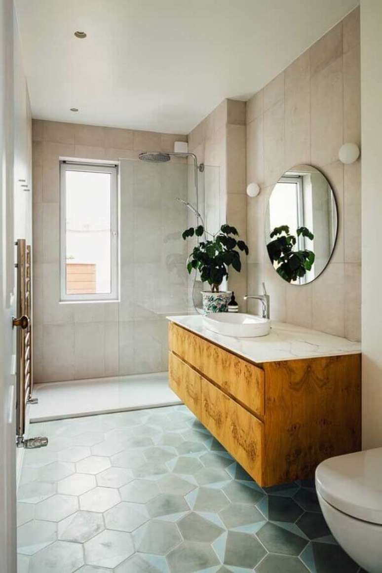 39. Banheiro simples decorado com gabinete de madeira e espelho para banheiro redondo sem moldura – Foto: Pinterest