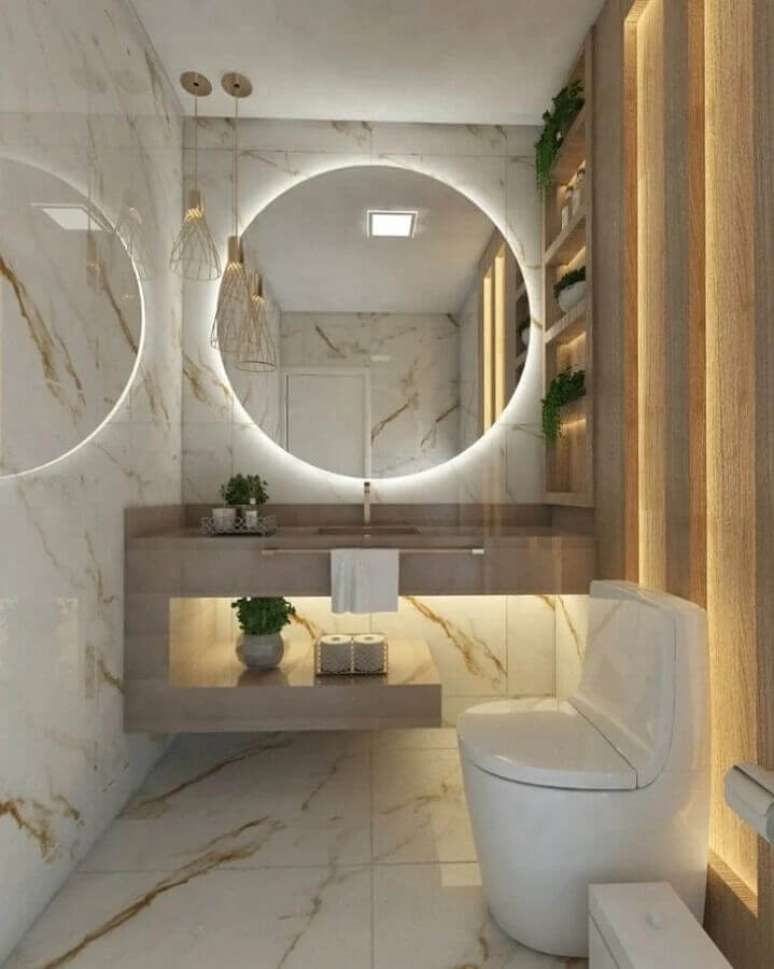 43. Decoração sofisticada com espelho redondo para banheiro com iluminação embutida – Foto: OKA Arquitetura