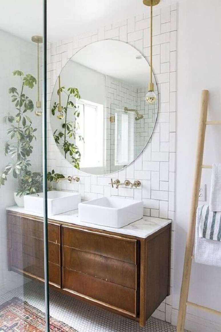 57. Decoração clean com espelho redondo para banheiro com gabinete suspenso de madeira – Foto: PURE Design Inc.