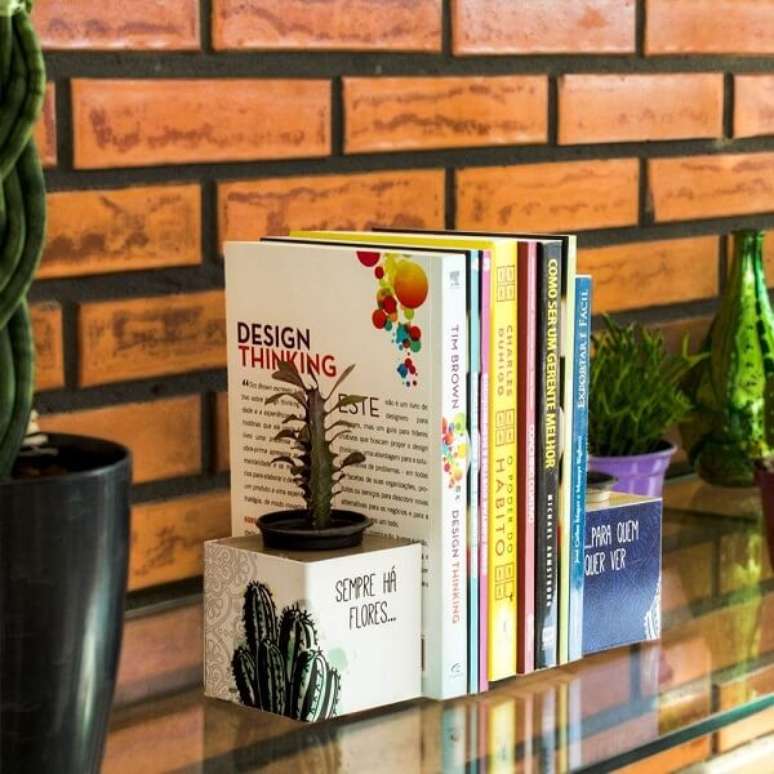 43. O aparador de livros para sala com vaso permite que voc&ecirc; cultive suculentas e cactos. Fonte: Pinterest