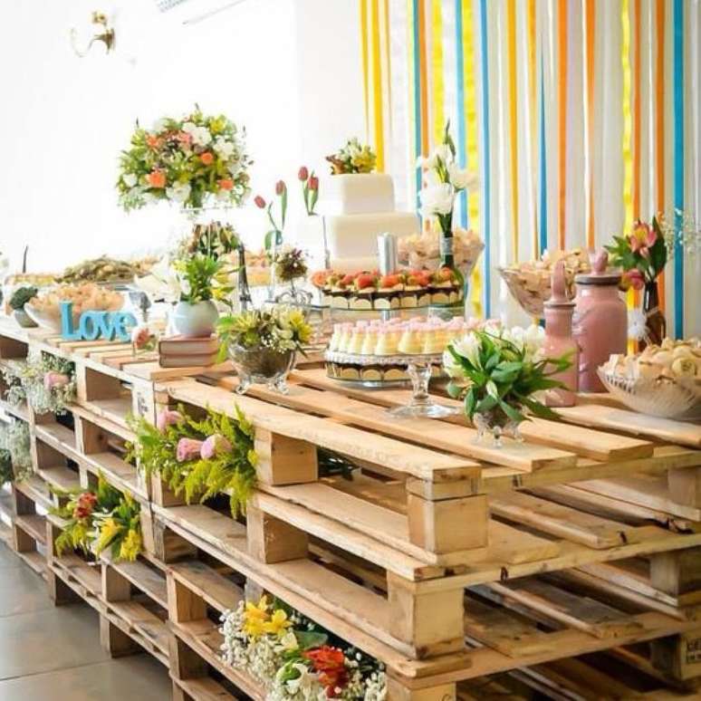 12- Mesa de doces com pallets de madeira são elementos de decoração de casamento rústico em espaços abertos