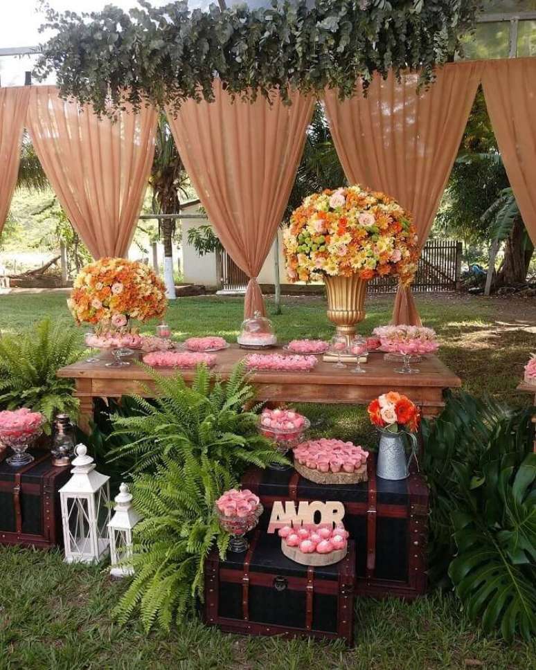 60. Arranjos de flores grandes e doces em forminhas cor de rosa para decoração de casamento ar livre rústico – Foto: Pinterest