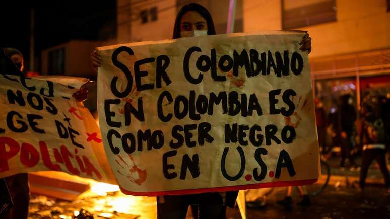 'Ser colombiano na Colômbia é como ser negro nos Estados Unidos', diz manifestante por meio de um cartaz