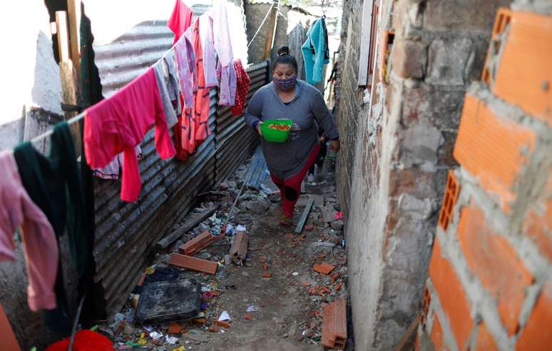 Mulher volta para casa após receber vasilha de sopa durante a pandemia de Covid-19 em Villa Azul, nos arredores de Buenos Aires
29/07/2020 REUTERS/Agustin Marcarian