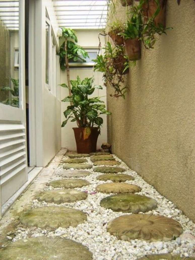 29. Jardim de inverno no quarto simples com vasos de parede e caminho de pedra. Fonte: Pinterest