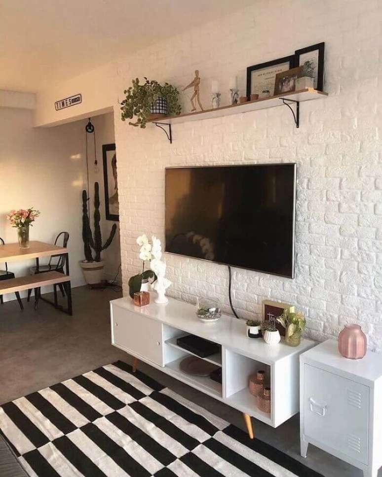 34. Sala decorada com tapete listrado preto e branco e parede de tijolinho a vista branco – Foto: Pinterest