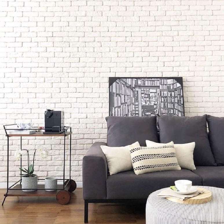33. Decoração clean para sala de estar com parede de tijolinho branco e sofá cinza – Foto: Apto41