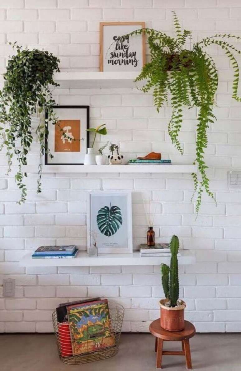 29. Parede de tijolinho branco decorada com prateleiras para quadros e vasos &ndash; Foto: Apartment Therapy