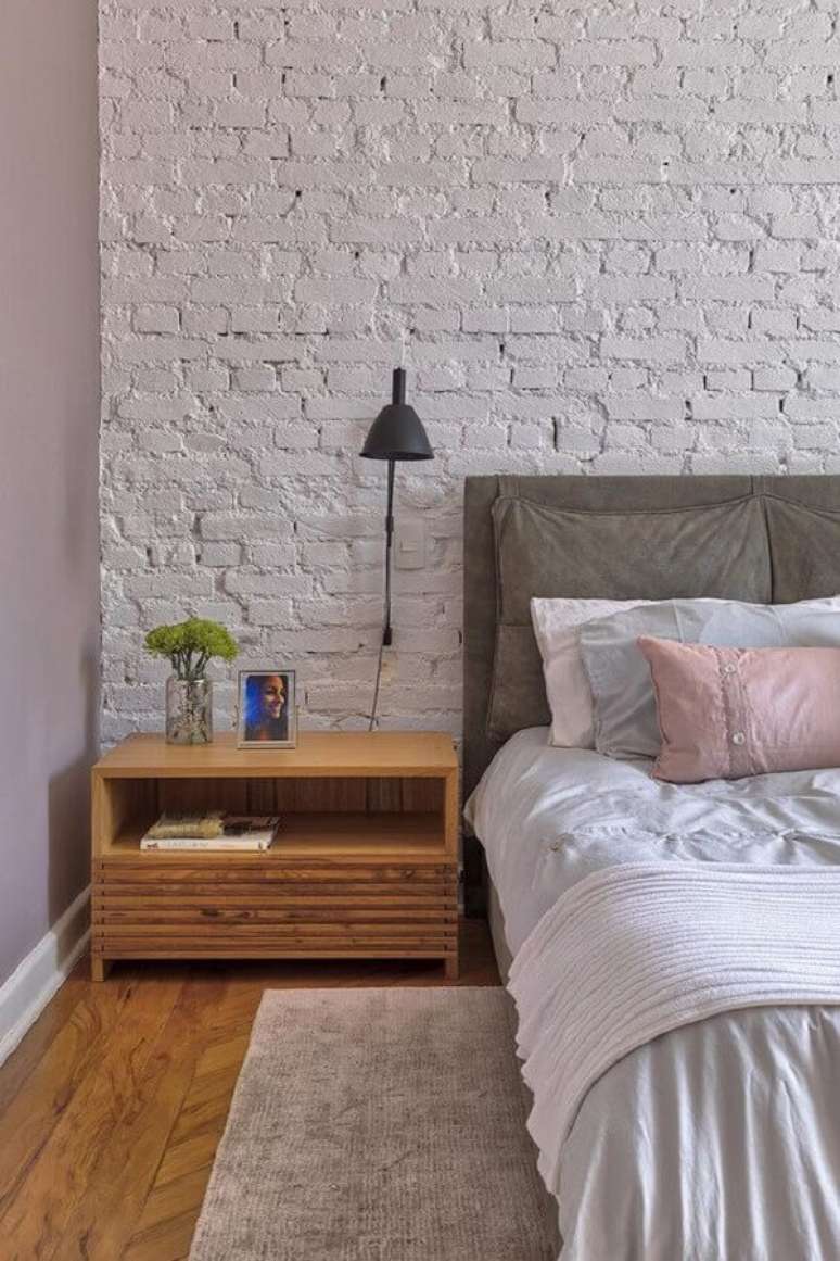 30. Quarto de casal decorado com criado mudo de madeira e parede com revestimento tijolinho branco r&uacute;stico &ndash; Foto: Casa de Valentina