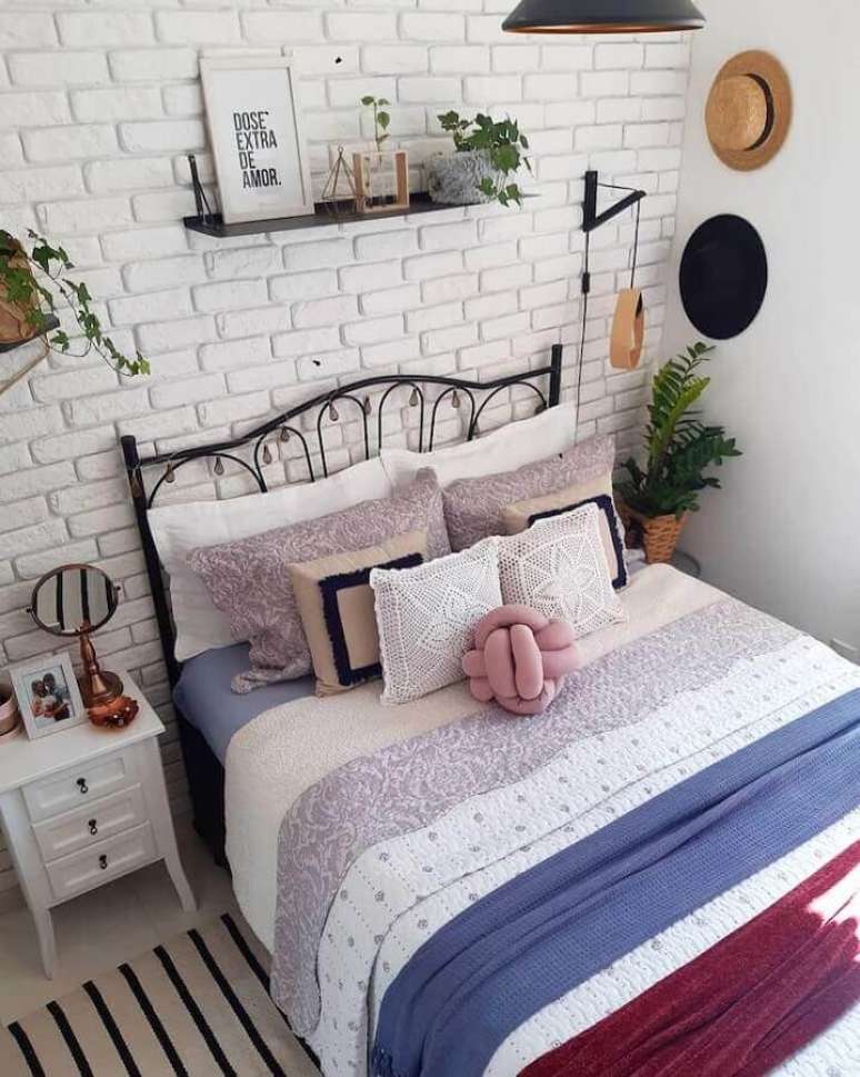 8. Quarto simples decorado com cama de ferro e papel de parede tijolinho branco – Foto: Jeito de Casa