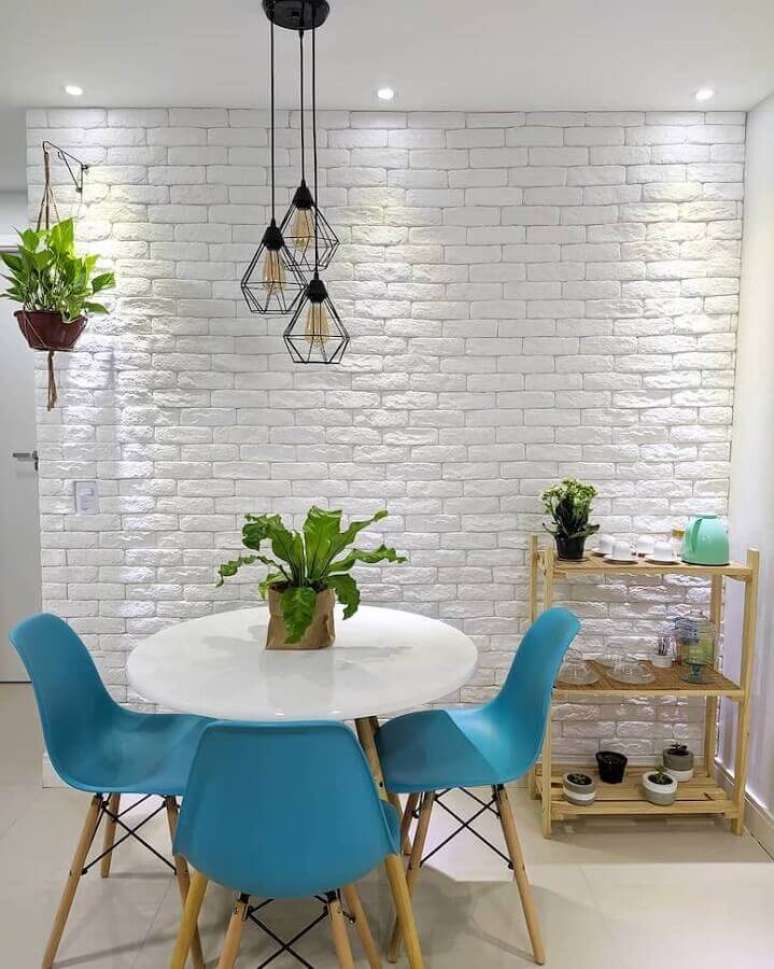 13. Decoração de sala de jantar simples com cadeiras azuis e parede de tijolinho a vista branco – Foto: Nosso Apê 103