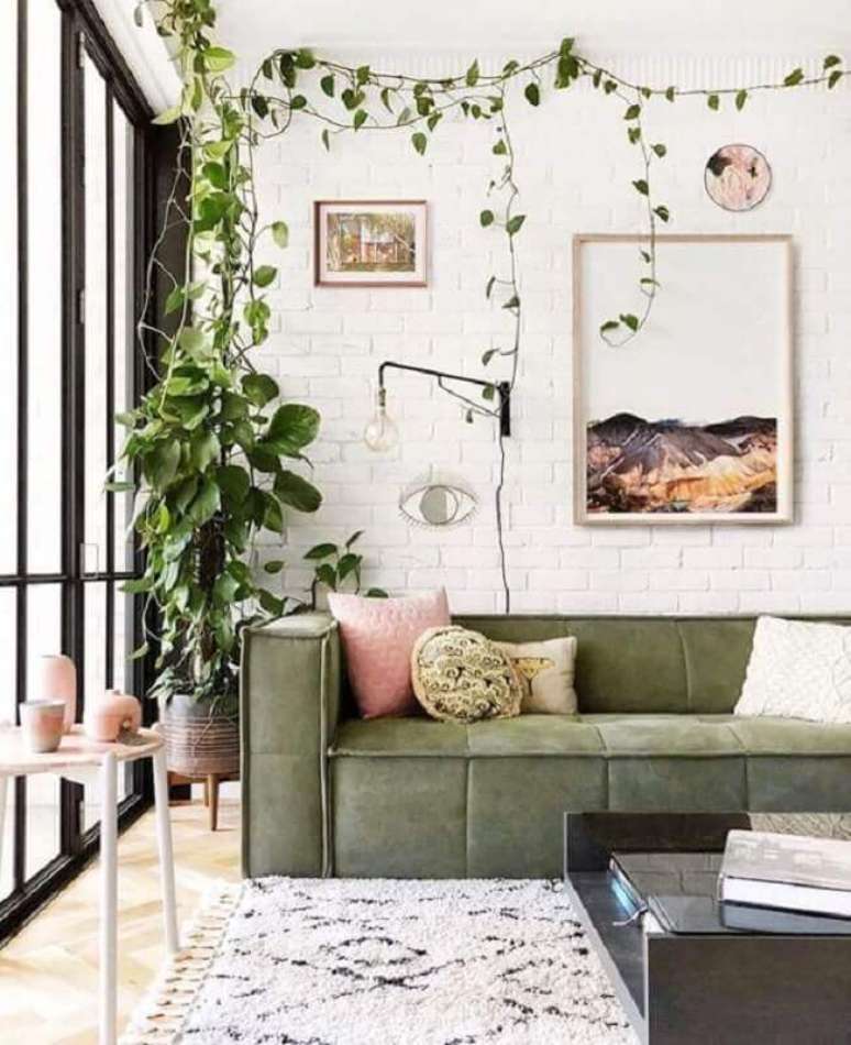 11. Decoração de sala com plantas, sofá verde musgo e parede de tijolinho branco – Foto: Casa Très Chic