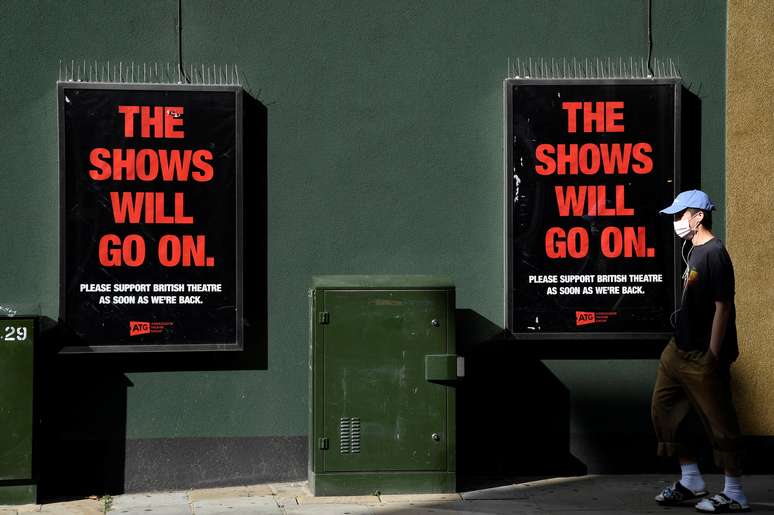 Homem usando m&aacute;scara de prote&ccedil;&atilde;o passa pela frente de cartazes na frente do New Theatre Oxford, em meio &aacute; pandemia da Covid-19), em Oxford. 17/9/2020. REUTERS/Toby Melville