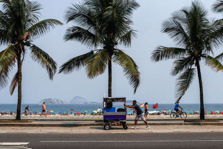 Apesar do clima parcialmente nublado e da proibição de estacionar na orla, uma grande quantidade de pessoas vão a praia de Ipanema, no Rio de Janeiro (RJ), neste sábado (19). 