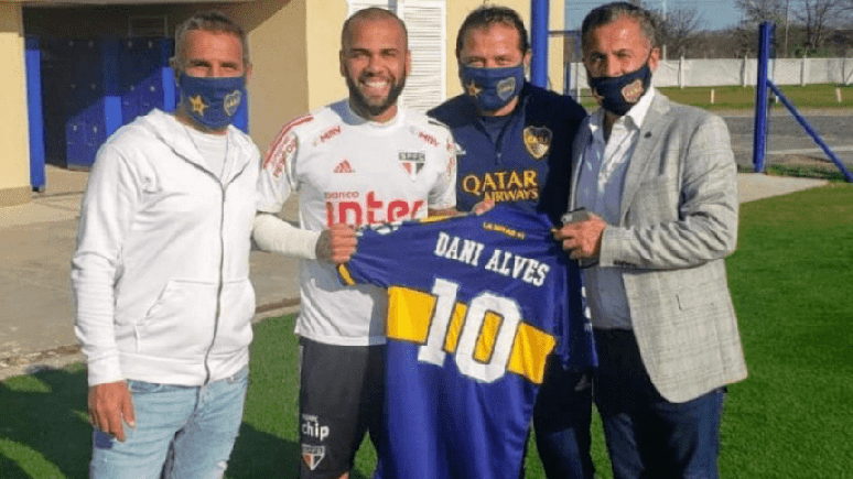 Daniel Alves recebeu a camisa da equipe de Buenos Aires das mãos de executivos do clube (Foto: Reprodução)