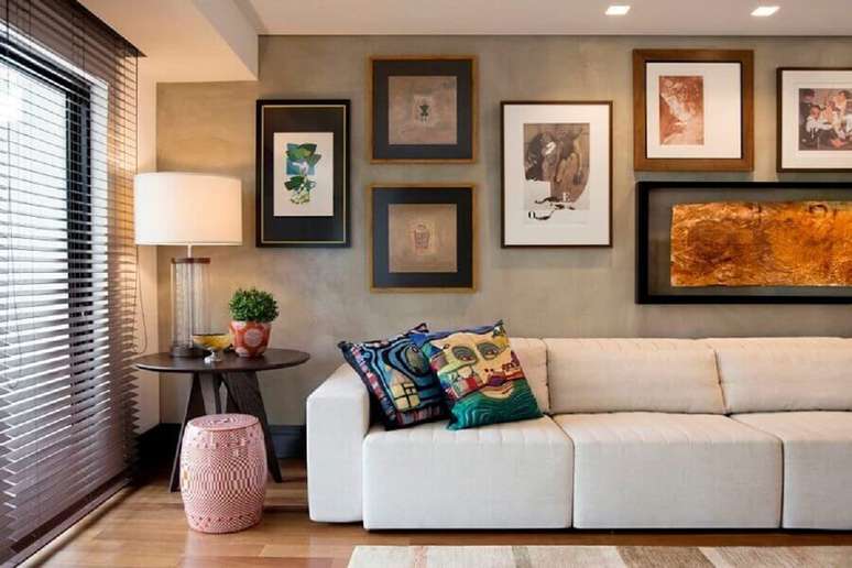 2. Sala moderna e sofisticada decorada com sofá 3 lugares retrátil confortável e parede de cimento queimado com vários quadros – Foto: Elmor Arquitetura