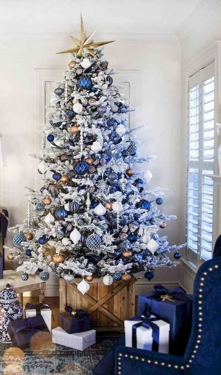 23. A estrela dourada foi colocada no topo da &aacute;rvore de natal branca e azul. Fonte: Pinterest