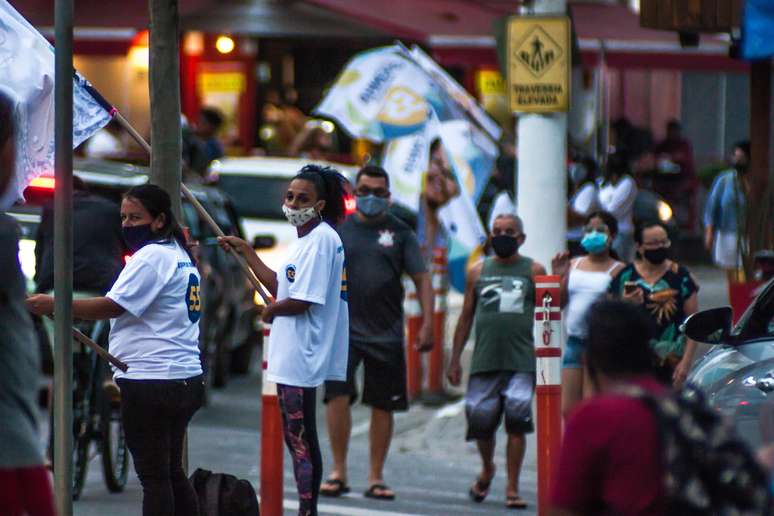 Campanha política toma cruzamento no Perequê em Ilhabela, SP, no fim desta tarde de terça-feira. Cabos eleitorais agitam bandeiras e distribuem santinhos aos transeuntes e motoristas.