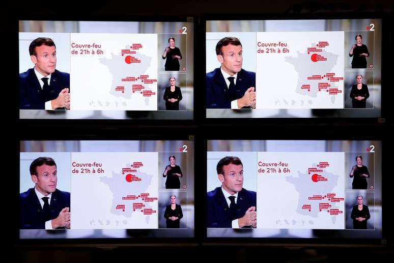 Presidente franc&ecirc;s, Emmanuel Macron, &eacute; visto em televisores durante entrevista &agrave; TV estatal para anunciar medidas de combate &agrave; Covid-19
14/10/2020
REUTERS/Benoit Tessier