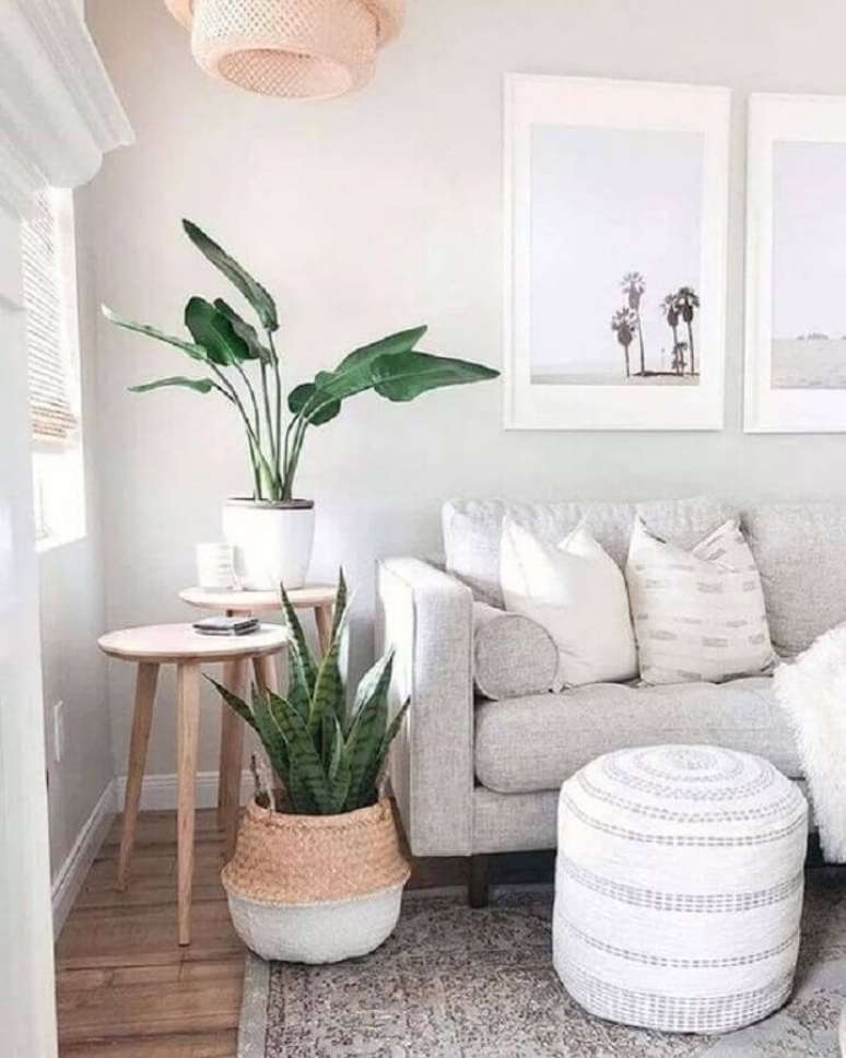 14. Sala clean decorada com sofá cinza claro e mesa de canto redonda madeira com pés palito – Foto: Pinterest