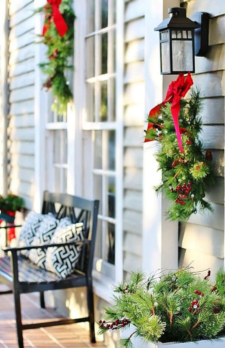 22. Decoração de natal para jardim externo com ramos e laços vermelhos. Fonte: Pinterest