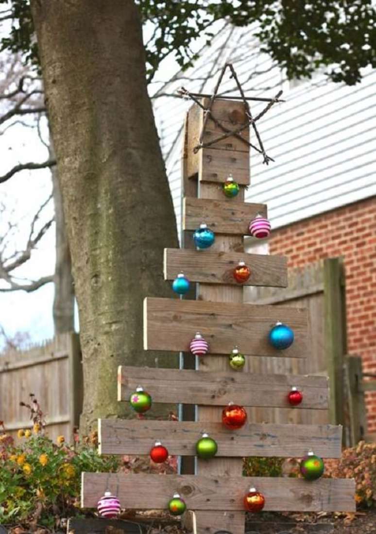 32. Decoração de natal simples e barata para jardim feita com árvore de madeira e bolas coloridas. Fonte: Pinterest