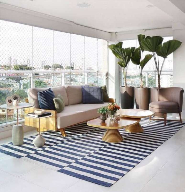 24. Mesa de canto redonda para decora&ccedil;&atilde;o de varanda ampla com tapete listrado &ndash; Foto: Casa das Amigas