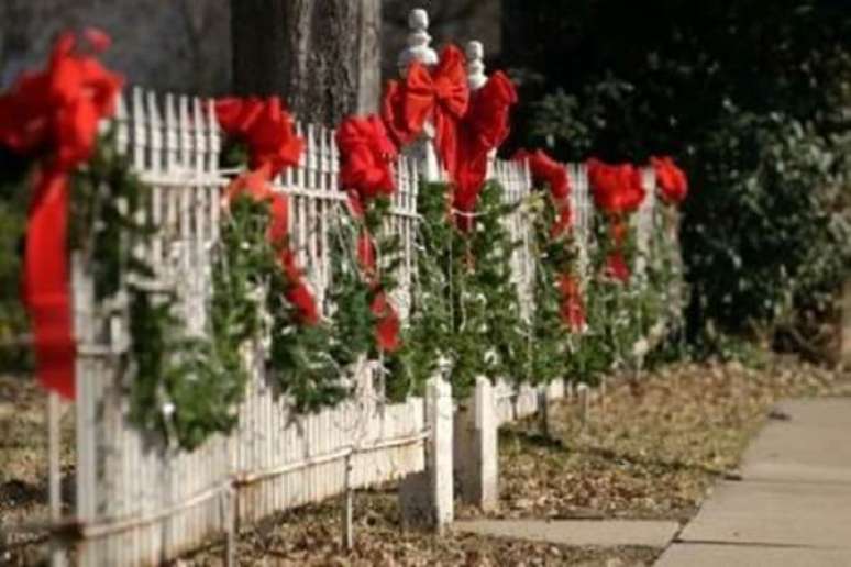 15. Laços vermelhos e luzes decoram a cerca da residência. Fonte: Pinterest