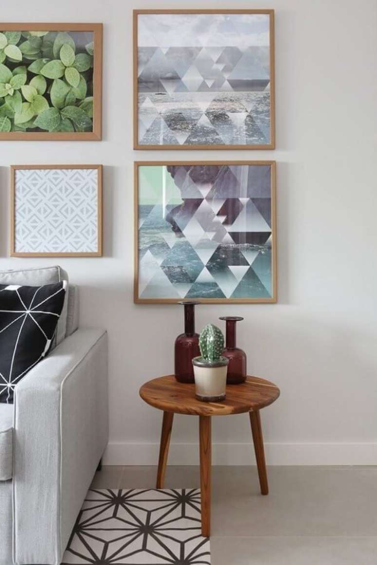 31. Mesa de canto redonda madeira para decoração de sala cinza com vários quadros na parede – Foto: Pinterest