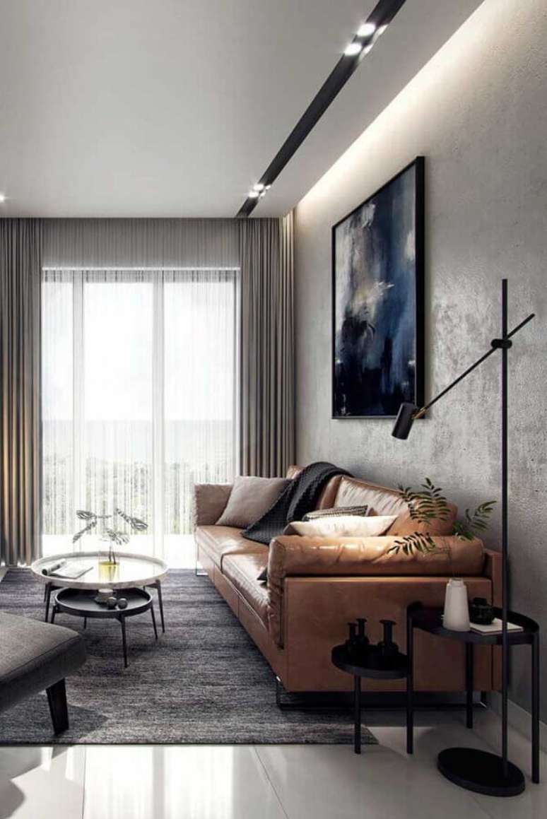 40. Mesa redonda de canto para sala para sala moderna decorada com parede de cimento queimado e sofá de couro marrom – Foto: Futurist Architecture