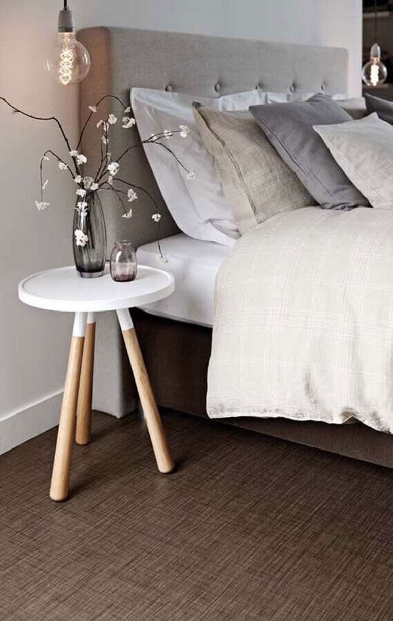 50. Mesa de canto redonda retrô para decoração de quarto com cabeceira estofada cinza – Foto: Pinterest