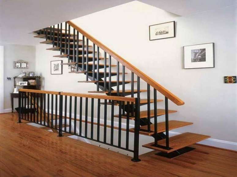 25. Escada de madeira simples com guarda-corpo de ferro preto e corrimão de madeira – Foto: Mathewmitchell Inspirations