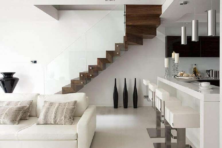 39. Ambiente super moderno com decoração toda branca com guarda-corpo de vidro para escada de madeira escura – Foto: Elite Metalcraft