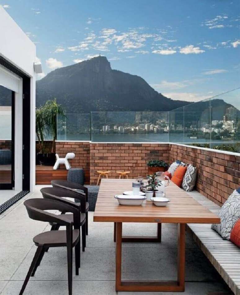 93. Varanda decorada com guarda corpo de vidro e tijolinho &agrave; vista &ndash; Foto: Habit&iacute;ssimo